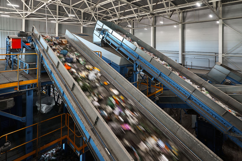 Trash transported to sort by conveyor in recycling plant workshop closeup. Production line at waste processing plant. Sustainable materials usage